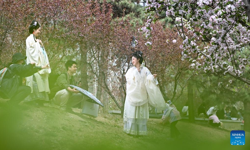 People take photos with blooming flowers in Chaoyang District of Beijing, capital of China, April 5, 2025. Qingming Festival, or Tomb-Sweeping Day, fell on April 4 this year. It is a traditional Chinese festival during which people pay tribute to the dead and worship their ancestors. The holiday also provides a short break for China's residents to engage in outdoor activities or go sightseeing. (Photo: Xinhua)