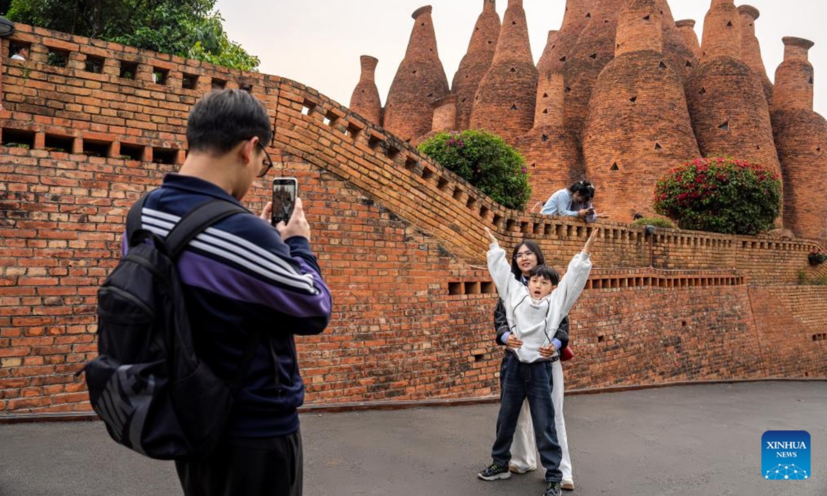 Tourists pose for photos at Dongfengyun Town in Mile City, Honghe Hani and Yi Autonomous Prefecture, southwest China's Yunnan Province, April 5, 2025. During this year's three-day Qingming Festival holiday, citizens and tourists came to this city's Huquan Ecological Park, Dongfengyun Town, Honghe Nativeland and other places to enjoy the spring scenery.  (Photo: Xinhua)