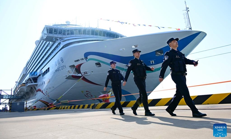 Immigration officers pass by the Adora Magic City at the Qingdao International Cruise Terminal in Qingdao, east China's Shandong Province, April 6, 2025. As China's first domestically built large cruise ship, Adora Magic City embarked on its commercial maiden voyage on Jan. 1, 2024. This time, the cruise ship made its debut in Qingdao, which is its first appearance in a Chinese port city other than its home port in Shanghai, and will depart for Jeju of South Korea and Fukuoka of Japan. Photo: Xinhua