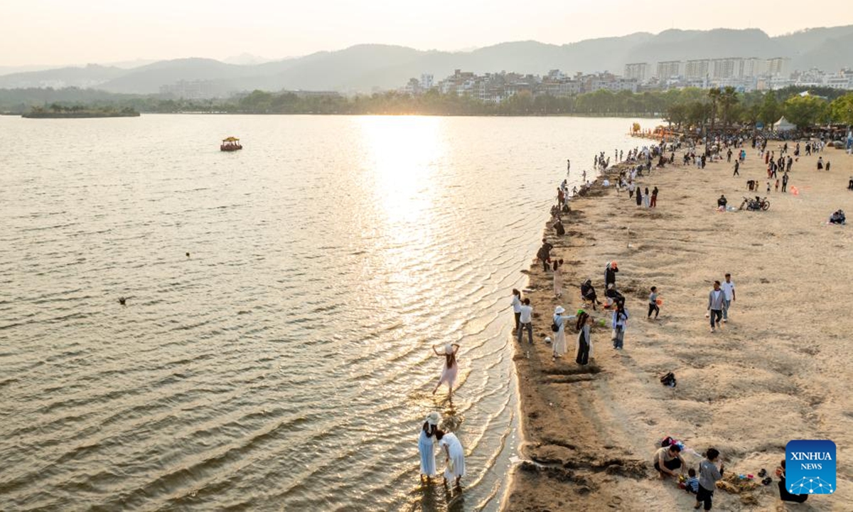 An aerial drone photo taken on April 4, 2025 shows tourists visiting Huquan Ecological Park in Mile City, Honghe Hani and Yi Autonomous Prefecture, southwest China's Yunnan Province. During this year's three-day Qingming Festival holiday, citizens and tourists came to this city's Huquan Ecological Park, Dongfengyun Town, Honghe Nativeland and other places to enjoy the spring scenery.  (Photo: Xinhua)