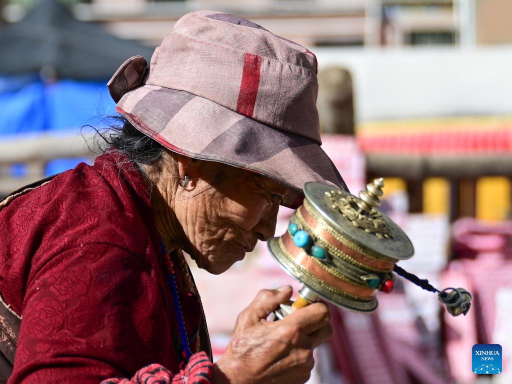 A pilgrim spins a prayer wheel at the Jiana mani stone mound in Yushu City, Yushu Tibetan Autonomous Prefecture, northwest China's Qinghai Province, April 6, 2025. The Jiana mani stone mound is a cultural relic under national protection. The mound is composed of billions of mani stones and used by local people when they hold prayers' wheels and mutter the six-syllable prayer to observe their daily ritual. (Xinhua/Zheng Huansong)