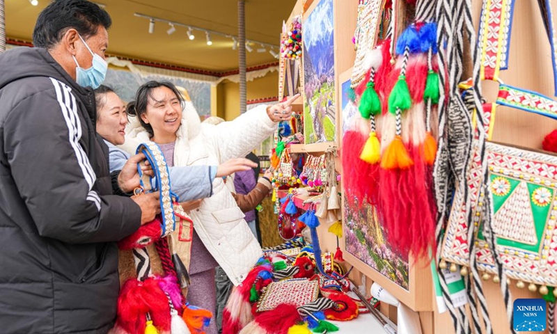 Tourists select souvenirs in Nyingchi, southwest China's Xizang Autonomous Region, April 3, 2025. In recent years, Nyingchi has managed to integrate flower viewing and tourism development, trying to transform the ecological scenery into economic value. From April 4 to April 6, 2025, the city received some 208,600 tourists, an increase of 20.58 percent year on year, with tourism revenue reaching 150 million yuan, an increase of 37.62 percent year on year, according to statistics. (Photo: Xinhua)