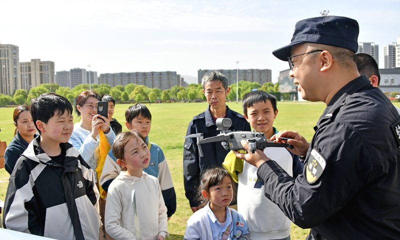 A police officer explains the role of police equipment to the public, including children, at a public square in Taizhou, East China's Zhejiang Province, on April 13, 2025 - the country's National Security Education Day. Photo: VCG