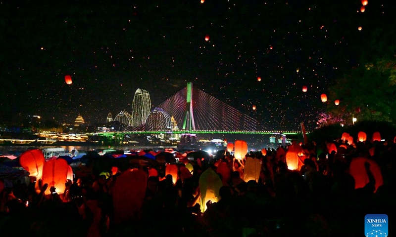 People fly Kongming lanterns, a kind of small hot-air paper balloon, by the Lancang River in Jinghong City, Xishuangbanna Dai Autonomous Prefecture, southwest China's Yunnan Province, April 13, 2025. A variety of folk cultural activities were held in Xishuangbanna Dai Autonomous Prefecture to celebrate the New Year of the calendar of the Dai ethnic group, which is also called the water-splashing festival. (Photo: Xinhua)