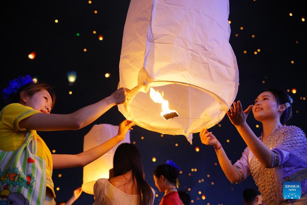 People fly a Kongming lantern, a kind of small hot-air paper balloon, by the Lancang River in Jinghong City, Xishuangbanna Dai Autonomous Prefecture, southwest China's Yunnan Province, April 13, 2025. A variety of folk cultural activities were held in Xishuangbanna Dai Autonomous Prefecture to celebrate the New Year of the calendar of the Dai ethnic group, which is also called the water-splashing festival. (Photo: Xinhua)