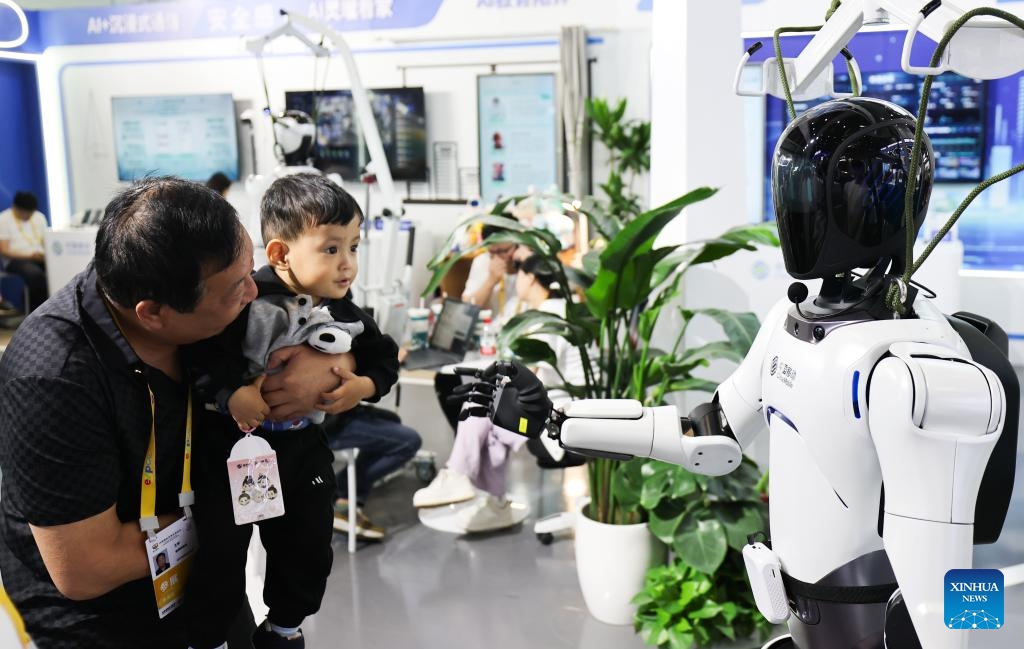 A child interacts with a robot at the 5th China International Consumer Products Expo (CICPE) in Haikou, south China's Hainan Province, April 14, 2025. This year's expo highlights future technology through the debut of various cutting-edge robots. By showcasing AI-powered functionalities and real-world applications, these robots offer a glimpse into the future of daily life. (Photo: Xinhua)