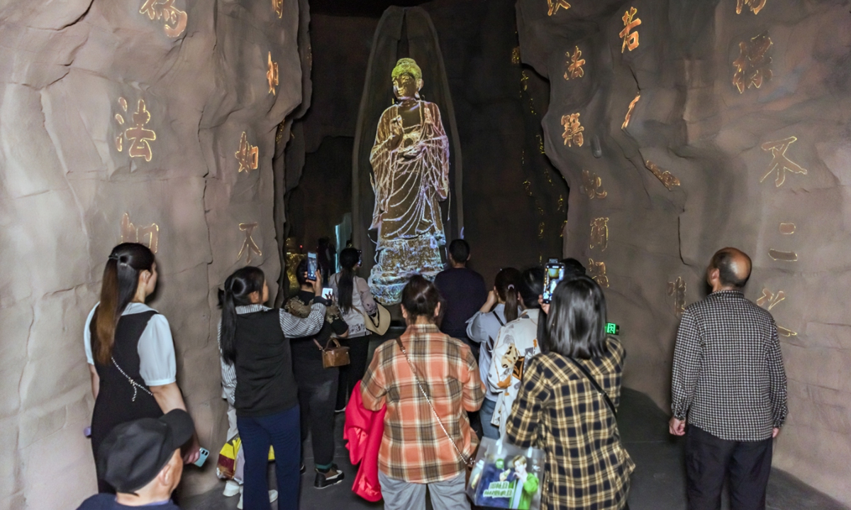 Visitors explore an exhibition at the Digital Exhibition Center of the Stone Caves in Anyue county, Southwest China's Sichuan Province, on April 16, 2025. Through the Tang (618-907) and Song (960-1279) dynasties, Anyue stone carving developed to its peak with the features of abundant, exquisite and magnificent. Now there are more than 100,000 stone statues preserved at about 230 sites in Anyue. Photo: VCG