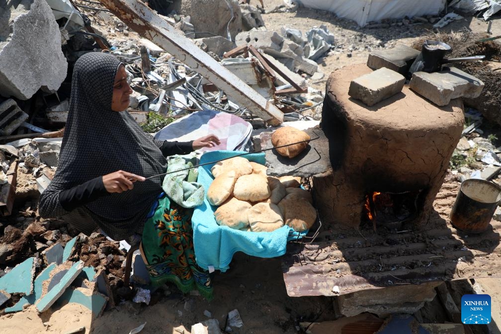 A displaced Palestinian woman makes bread at a temporary shelter in Gaza City, on April 15, 2025. (Photo: Xinhua)