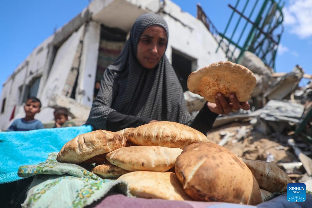 A displaced Palestinian woman makes bread at a temporary shelter in Gaza City, on April 15, 2025. (Photo: Xinhua)