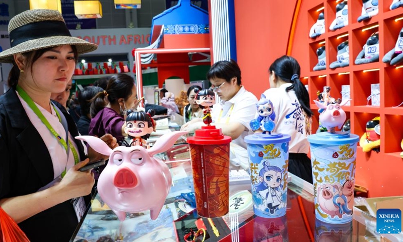 Visitors look at products themed on Chinese movie Ne Zha 2 at the 5th China International Consumer Products Expo (CICPE) in Haikou, south China's Hainan Province, April 16, 2025. From intangible cultural heritage skills to technological trendy products, Chinese brands showcased its charm at the ongoing CICPE in Haikou, attracting the attention of many visitors. (Photo: Xinhua)