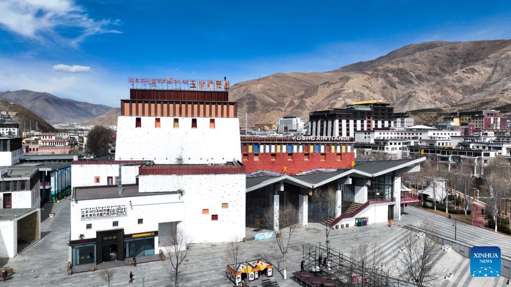 An aerial drone photo taken on April 10, 2025 shows a theater in Yushu City of Yushu Tibetan Autonomous Prefecture, northwest China's Qinghai Province. From a bird's eye view, the densely built houses of Yushu City nestle in mountain valleys, while the Batang River meanders through the city like a jade belt. The cityscape of Yushu presents a distinct sense compared to the traditionally perceived cold and arid highland cities. It resembles a city of water with the rich waterways of the Yangtze River source enveloping the main urban area in lush wetlands. (Photo: Xinhua)