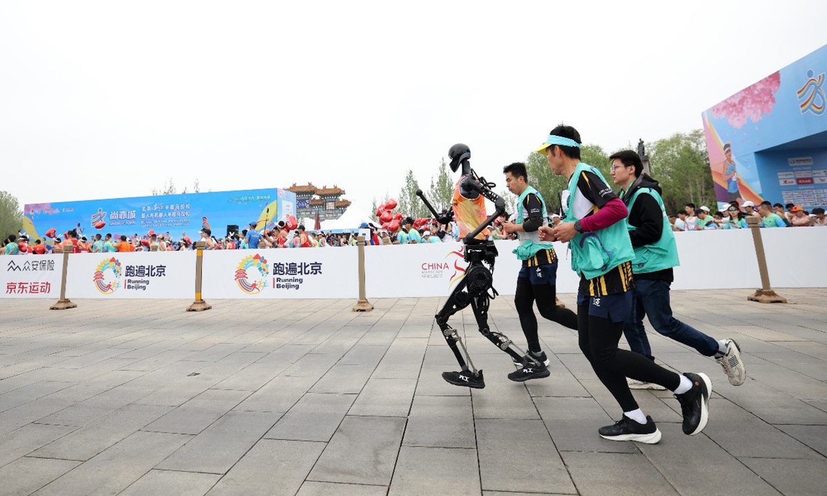 A humanoid robot races in the company of assistants at the humanoid robot half-marathon in Beijing on April 19, 2025. Photo: Courtesy of Beijing Innovation Center of Humanoid Robotics Co