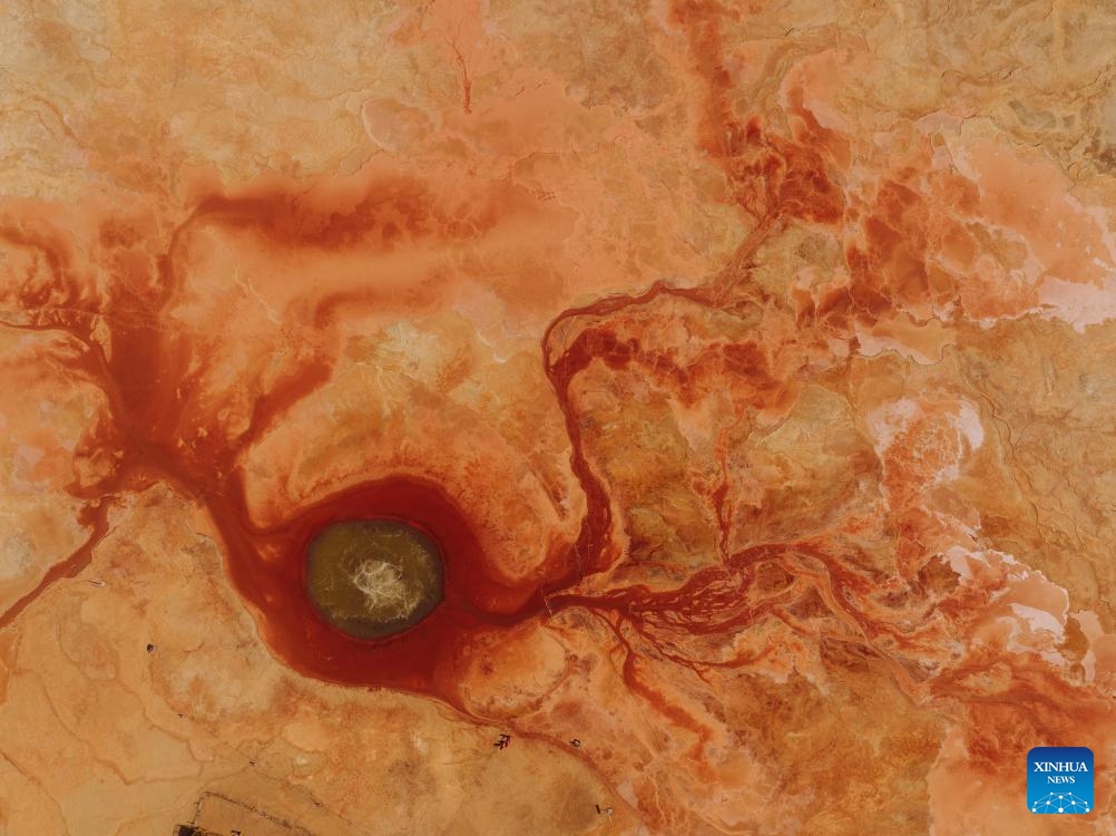 An aerial drone photo taken on April 19, 2025 shows the Aiken Spring in Mangya, Haixi Mongolian and Tibetan Autonomous Prefecture of northwest China's Qinghai Province. Located in northwest China's Qinghai Province, Aiken Spring is dubbed the Eye of the Earth. This rare geological wonder forms a unique pupil shape from above, with spring water and surrounding deep red sediments resembling an eye embedded in the land. (Photo: Xinhua)