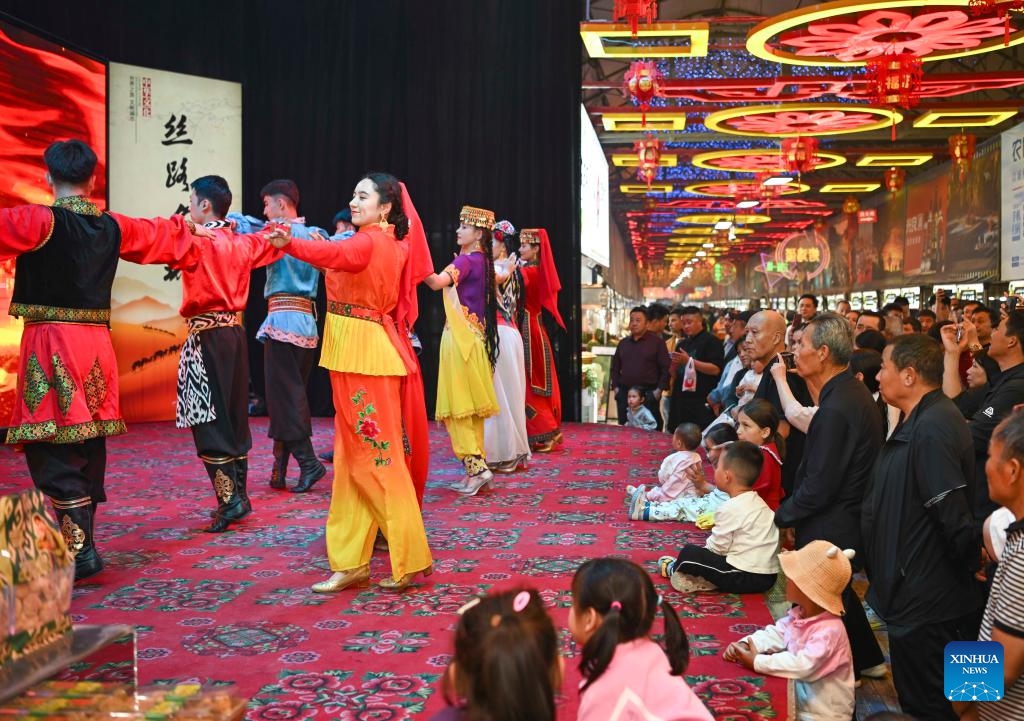 Nurbiye Jureait and colleagues stage a performance at the night market in Hotan, northwest China's Xinjiang Uygur Autonomous Region, April 15, 2025. The Hotan night market in Xinjiang, which integrates food, entertainment, and cultural features, is a popular destination for tourists. The Hotan cultural troupe holds artistic performances all year round at the night market to enhance the cultural life and tourism experience of local residents and visitors. (Photo: Xinhua)
