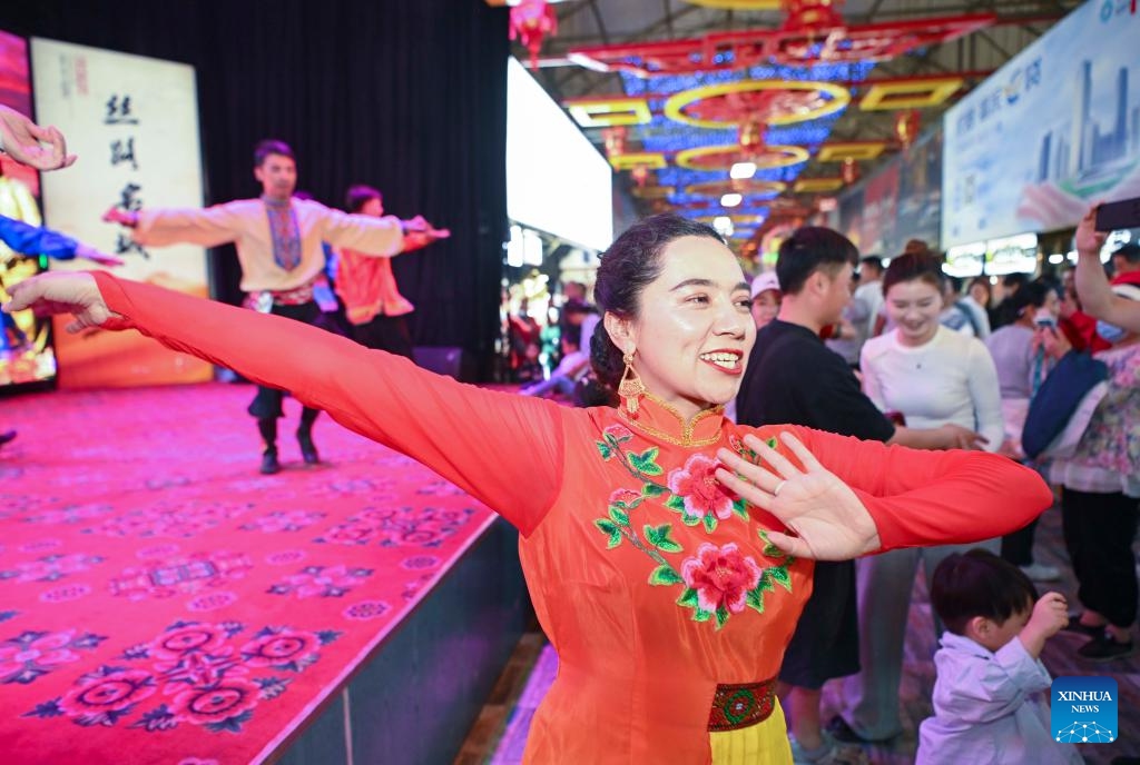 Nurbiye Jureait dances at the night market in Hotan, northwest China's Xinjiang Uygur Autonomous Region, April 16, 2025. The Hotan night market in Xinjiang, which integrates food, entertainment, and cultural features, is a popular destination for tourists. The Hotan cultural troupe holds artistic performances all year round at the night market to enhance the cultural life and tourism experience of local residents and visitors. (Photo: Xinhua)