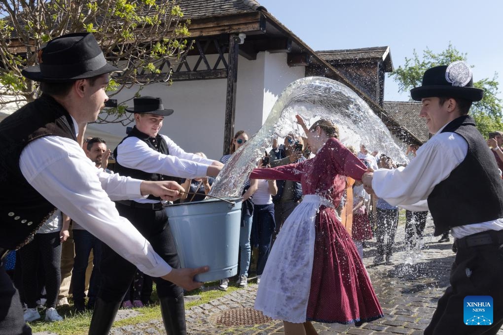 A man splashes water onto a woman during the traditional Easter celebration in Holloko, Hungary, on April 21, 2025. Local people from Holloko, which was inscribed on the World Heritage List, celebrate Easter with the traditional watering of the girls, a Hungarian tribal fertility ritual rooted in the area's pre-Christian past. (Photo: Xinhua)
