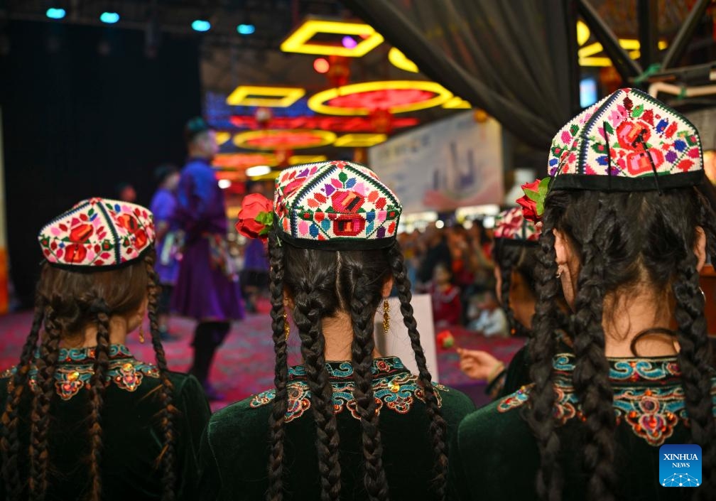 Artists from Hotan cultural troupe wait to stage a performance at the night market in Hotan, northwest China's Xinjiang Uygur Autonomous Region, April 15, 2025. The Hotan night market in Xinjiang, which integrates food, entertainment, and cultural features, is a popular destination for tourists. The Hotan cultural troupe holds artistic performances all year round at the night market to enhance the cultural life and tourism experience of local residents and visitors. (Photo: Xinhua)