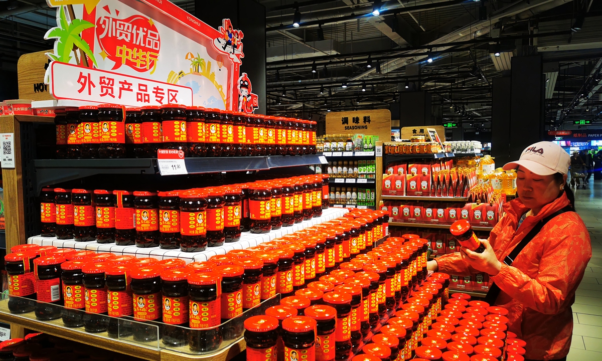 A customer examines a jar of chili sauce at the newly launched export trade product section inside a Yonghui Superstore in Beijing on April 22, 2025. The section, introduced as a pilot program, aims to attract domestic consumers while fulfilling the company's commitment to helping high-quality Chinese suppliers facing export challenges transition to the domestic market. Photo: VCG