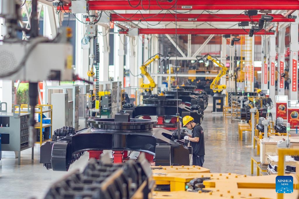 Staff members work on an assembly line of excavators for export to Laos and Myanmar at an equipment manufacturing company in southwest China's Chongqing Municipality, April 21, 2025. (Photo: Xinhua)