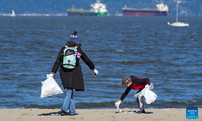 Volunteers pick up litter during a beach cleanup event at Kitsilano Beach in Vancouver, British Columbia, Canada, on April 22, 2025. Volunteers participated in the beach cleanup event here on Tuesday to mark Earth Day. (Photo: Xinhua)
