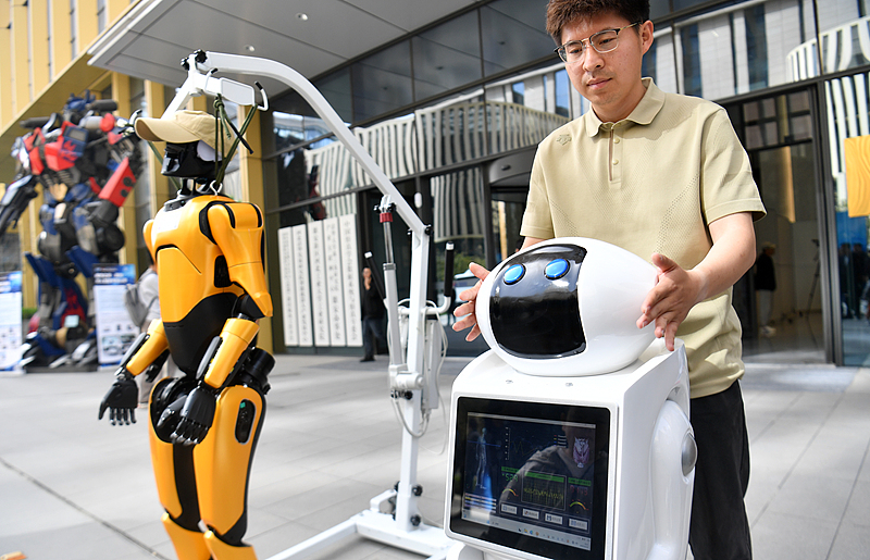 A visitor interacts with a robot during an international robot competition kicked off in the Xiong'an New Area, North China's Hebei Province, on April 23, 2025. The event attracted more than 70 tech innovation teams from leading tech companies and top universities both from China and abroad. Photo: VCG