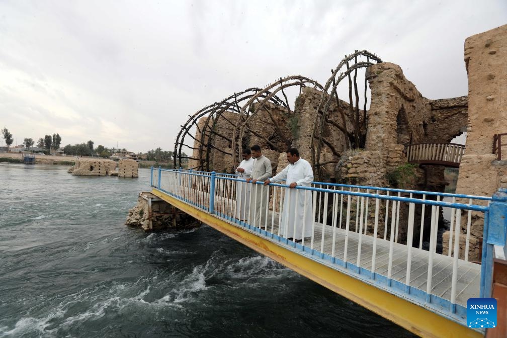 Visitors view Iraqi traditional waterwheels made from tree branches on the banks of the Euphrates River in Anbar Province, Iraq, April 21, 2025. (Photo: Xinhua)