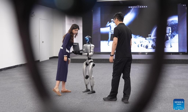A Unitree G1 humanoid robot carries an object with both hands at an exhibition hall of Unitree Robotics in Hangzhou, east China's Zhejiang Province, April 23, 2025. The Unitree G1 humanoid robot demonstrated a series of newly updated actions Wednesday in Hangzhou. (Photo: Xinhua)