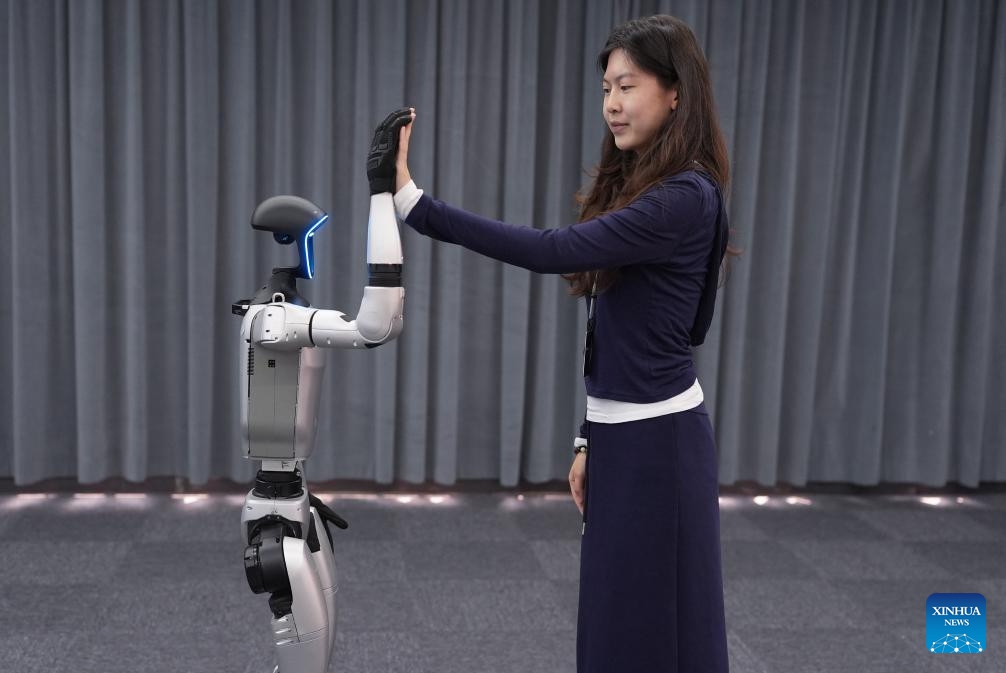 A Unitree G1 humanoid robot performs a high-five at an exhibition hall of Unitree Robotics in Hangzhou, east China's Zhejiang Province, April 23, 2025. The Unitree G1 humanoid robot demonstrated a series of newly updated actions Wednesday in Hangzhou. (Photo: Xinhua)