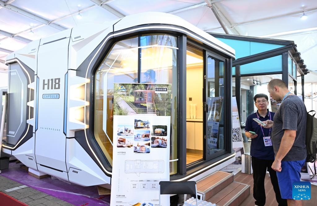 An overseas buyer talks with an exhibitor at an area featuring integrated housing products at the 137th edition of the Canton Fair in Guangzhou, south China's Guangdong Province, April 23, 2025. The second phase of the 137th edition of the Canton Fair themed on quality home furnishings opened on Wednesday. An area featuring integrated housing products was set up for the first time at the event to showcase mobile houses, modular houses, expandable houses and other related products. (Photo: Xinhua)