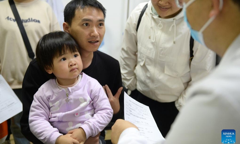 People communicate with a medical expert at a hospital in Bouyei-Miao Autonomous Prefecture of Qianxinan, southwest China's Guizhou Province, April 24, 2025. Recently, a congenital heart disease (CHD) screening program has been carried out in Guizhou Province. Children who are screened in accordance with surgical indications can receive free surgical treatment. The screening program, launched by the Chinese Red Cross Foundation, has supported nearly 10,000 children born with the CHD by offering them free surgeries. (Photo: Xinhua)
