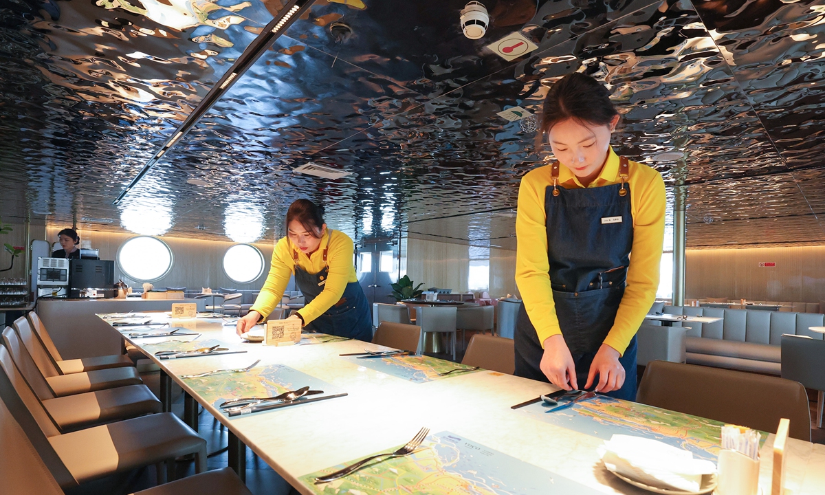 Workers prepare a dining table on a floating cruise hotel as it berths at a wharf in Lianyungang, East China's Jiangsu Province on April 28, 2025. The ship is China's first floating leisure facility converted from a vessel, offering accommodation, catering and entertainment services to visitors. The added value of China's marine tourism industry grew 9.2 percent year-on-year to 1.61 trillion yuan ($221.4 billion) in 2024, per the Ministry of Natural Resources. Photo: VCG