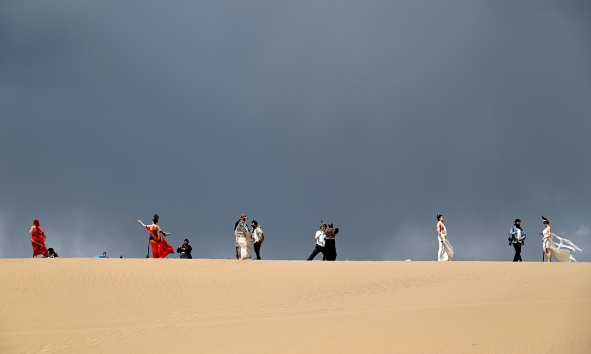 Tourists dressed as flying apsaras have their photos taken at the Mingsha Mountain and Crescent Spring scenic spot in Dunhuang, Northwest China's Gansu Province on April 28, 2025. The flying apsaras are typical images on murals in Dunhuang's Mogao Grottoes, a renowned UNESCO World Heritage site. Photo: VCG