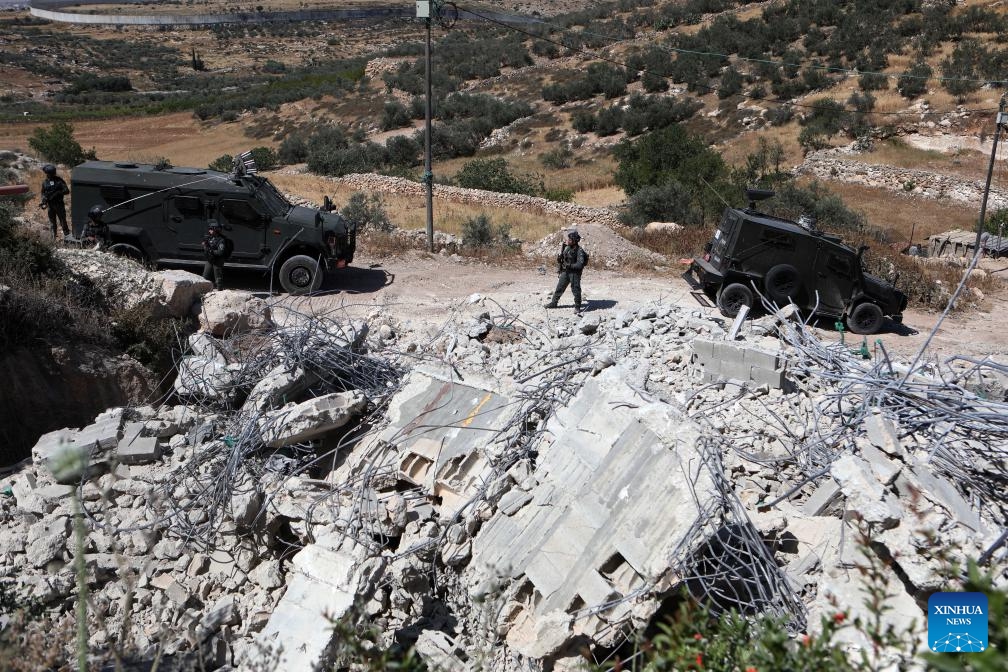 Israeli forces are seen after Israeli excavators demolish houses in the village of Idna, west of the West Bank city of Hebron, on April 28, 2025. The houses here were demolished due to a lack of Israeli-issue building permits, which Palestinians say are nearly impossible to obtain. (Photo: Xinhua)