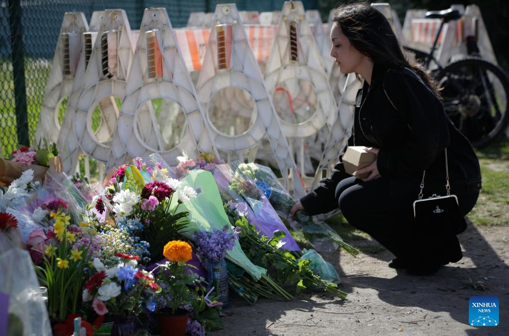 A woman lays flowers near the site of a car crash in Vancouver, British Columbia, Canada, April 27, 2025. A total of 11 people have been confirmed dead after a driver drove into a crowd at a street festival in Vancouver, Canada, on Saturday evening, said the police on Sunday. (Photo: Xinhua)