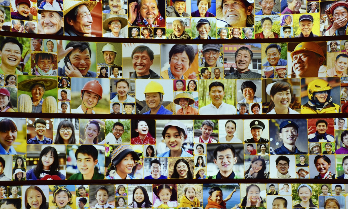  photo taken on November 6, 2022 shows a wall displaying photos of smiling people at an exhibition themed Forging Ahead in the New Era, which showcases China's achievements and development over the last decade, at the Beijing Exhibition Center. Photo: VCG