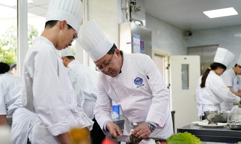 A teacher (R) instructs a student on making Sichuan cuisine at Sichuan Tourism University in Chengdu, southwest China's Sichuan Province, April 24, 2025. (Xinhua/Xu Bingjie)