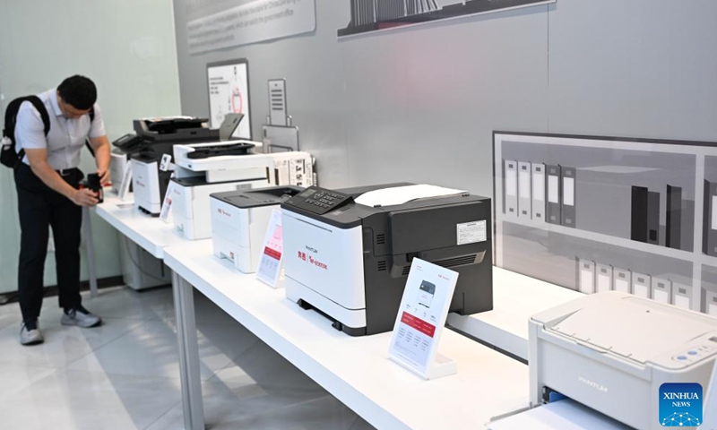 A visitor takes photos of printer products at Ninestar Corporation in Zhuhai, south China's Guangdong Province, April 29, 2025.