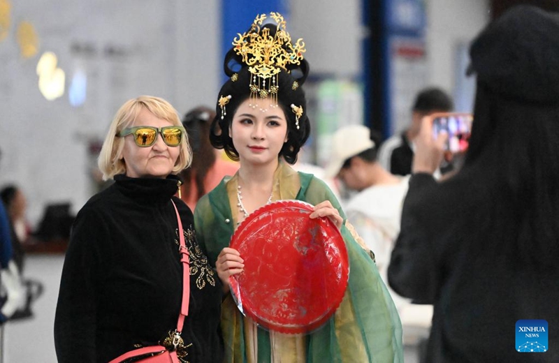 A foreign tourist poses for photo with a performer at Tianjin International Cruise Home Port in north China's Tianjin Municipality, May 1, 2025. Tianjin International Cruise Home Port welcomed the simultaneous berthing of three international cruise ships on the first day of May Day holiday, which was the first time since its resumption of operations. According to statistics, on May 1, the number of inbound and outbound passengers reached nearly 15,000, with over 400 travelers applying for visa-free entry with a period of 240 hours. Photo: Xinhua