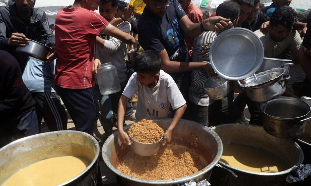 Palestinians receive free food from a food distribution center in Gaza City, on May 9, 2025. (Photo by Rizek Abdeljawad/Xinhua)
