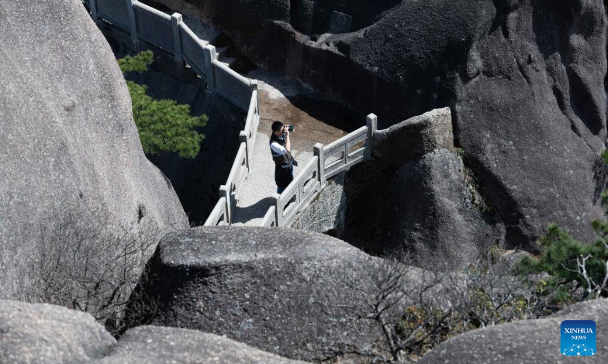 Wu Yijun, a senior engineer of the parks and woods bureau of Huangshan Scenic Area management committee, checks the condition of an ancient pine through telescope at Lianhua Peak of Huangshan in east China's Anhui Province, on April 23, 2025. Huangshan Mountain is a listed UNESCO World Cultural and Natural Heritage Site, which has attracted a large number of tourists. To minimize the impact of visitors on its vegetation growth, the Huangshan Scenic Area rotates days off for its major scenic spots, as a special arrangement for ecological protection. The Tiandu Peak, one of the most popular sites in the Huangshan scenic area, ended its more than five-year 