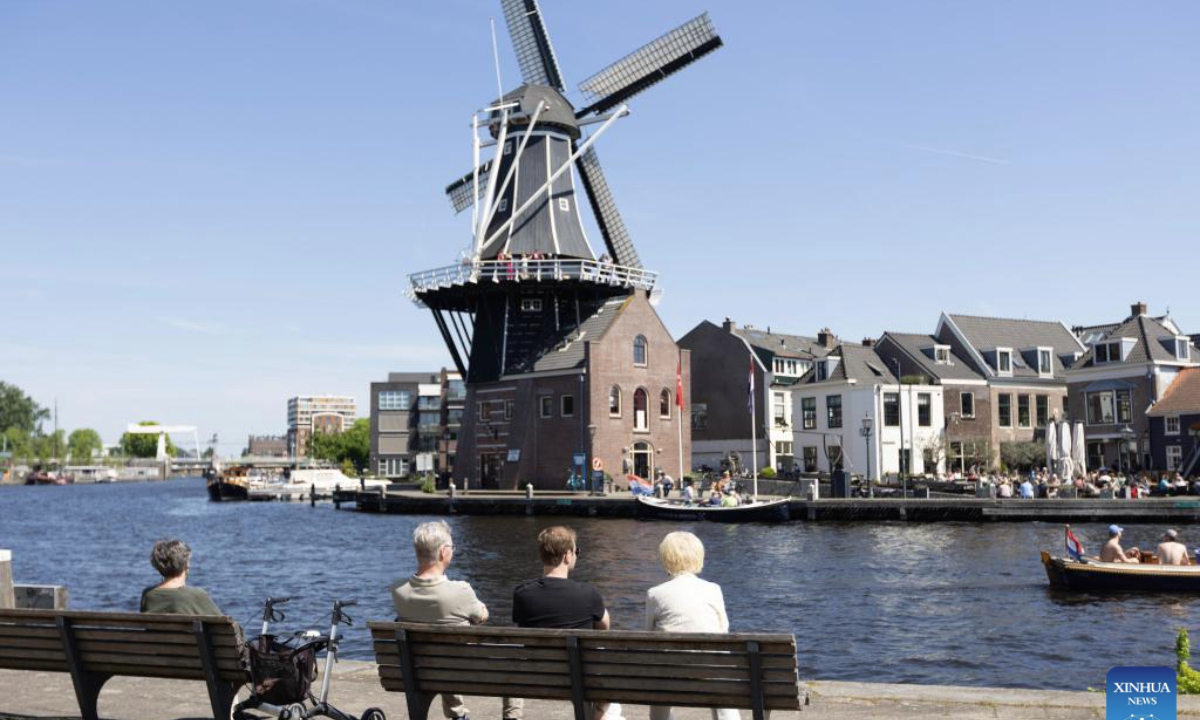People enjoy the view of the De Adriaan windmill during the National Mill Day celebration in Haarlem, the Netherlands, May 10, 2025. The National Mill Day is celebrated annually on the second weekend in May. (Photo by Sylvia Lederer/Xinhua)