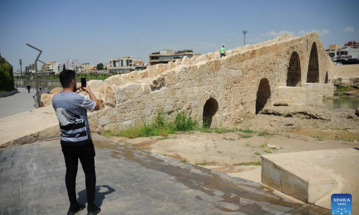A man takes photos of the ancient Dalal Bridge in Dohuk province, Iraq, May 10, 2025. The construction of Dalal Bridge dates back to the period of the Byzantine Empire. (Xinhua/Duan Minfu)