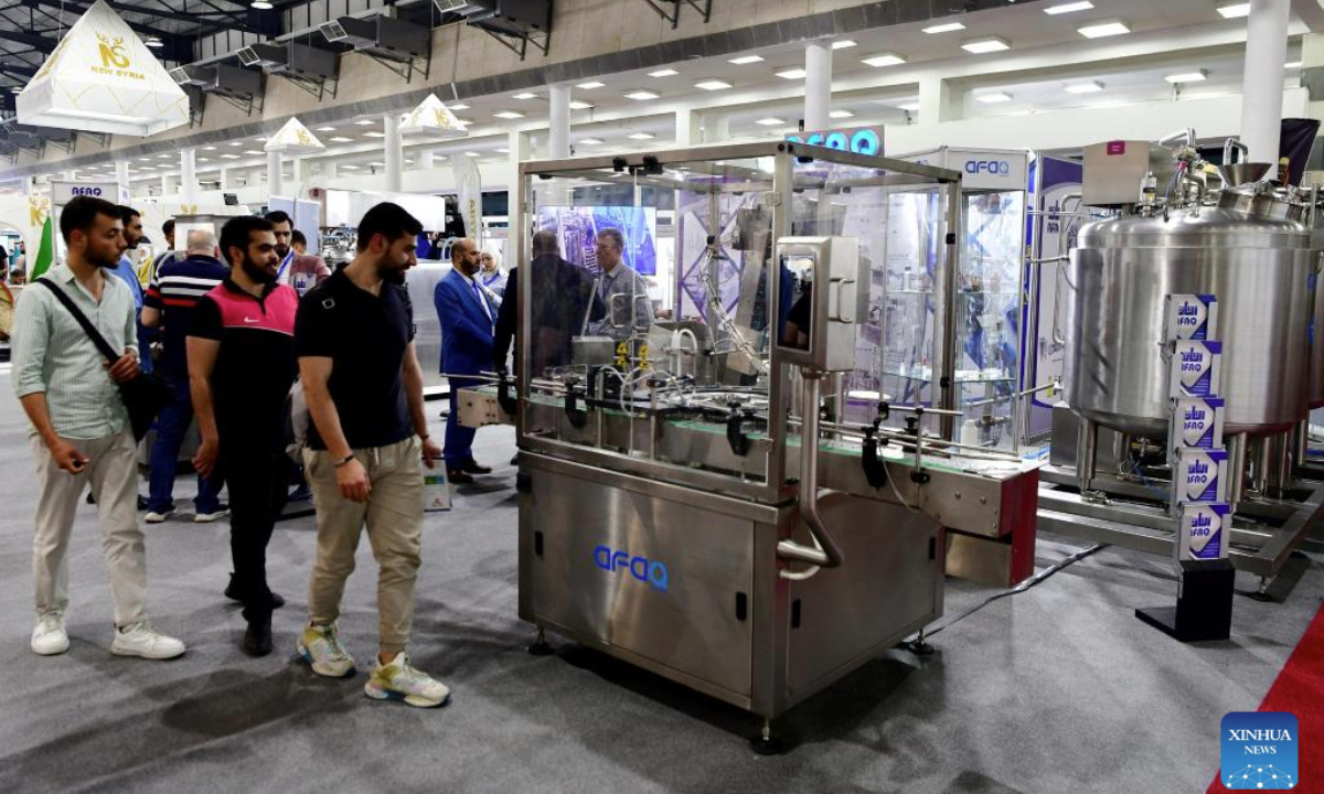 Attendees observe a machine on display at the Techno Build exhibition, in Damascus, Syria, on May 10, 2025. The fair, showcasing a wide range of services and solutions for building, construction and infrastructure, drew more than 500 local and international companies. (Photo by Ammar Safarjalani/Xinhua)