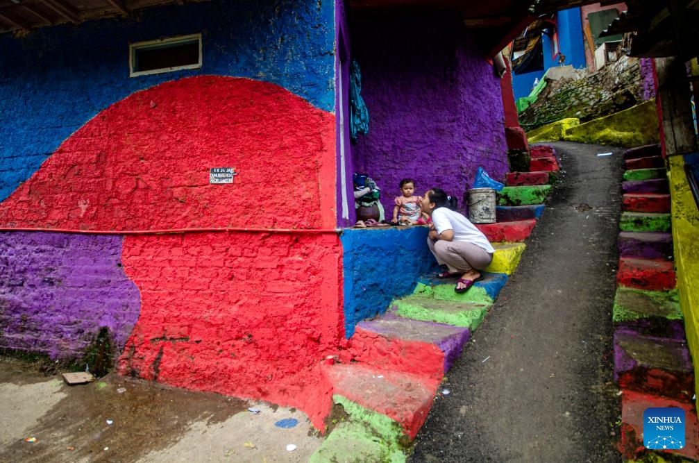 A woman plays with her child at Katumbiri village known for its colourful houses in Bandung, West Java, Indonesia, May 7, 2025. (Photo: Xinhua)