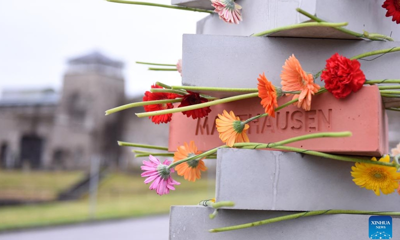 This photo taken on May 5, 2025 shows flowers on a new monument at Mauthausen Concentration Camp Memorial in Upper Austria, Austria, May 5, 2025. The Mauthausen Concentration Camp was the first concentration camp established in a foreign country by Nazi Germany. It was built in August 1938 and liberated by the Allied forces in May 1945. The camp was converted into a museum after World War II. Ceremony was held every year to pay tribute to victims killed by the Nazi Germany. (Photo: Xinhua)