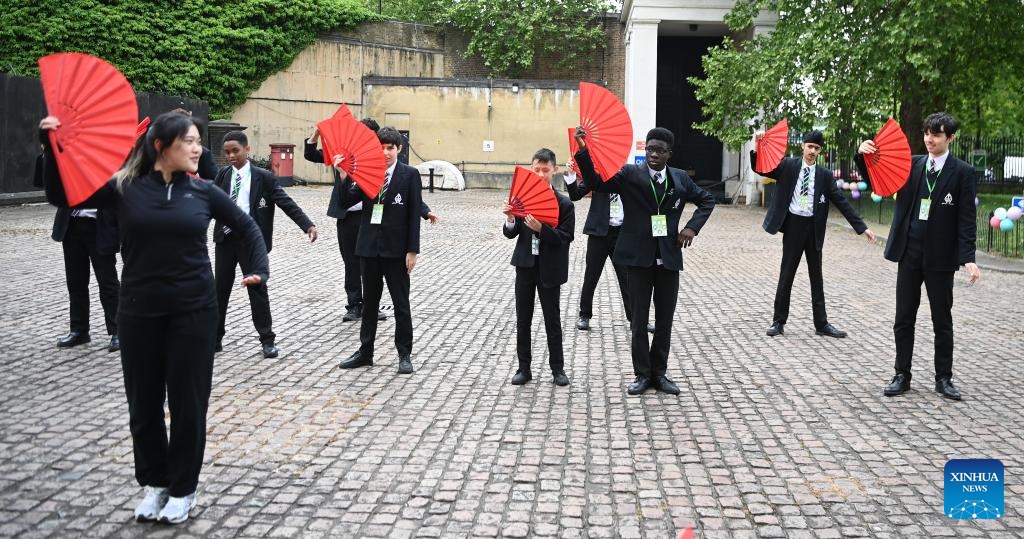 Students learn Chinese fan dance during an event marking Chinese Language Day in London, Britain, on May 8, 2025. An event marking this year's Chinese Language Day was held on Thursday in London, bringing together around 100 students from six schools across Britain to celebrate the Chinese language and culture. (Photo: Xinhua)