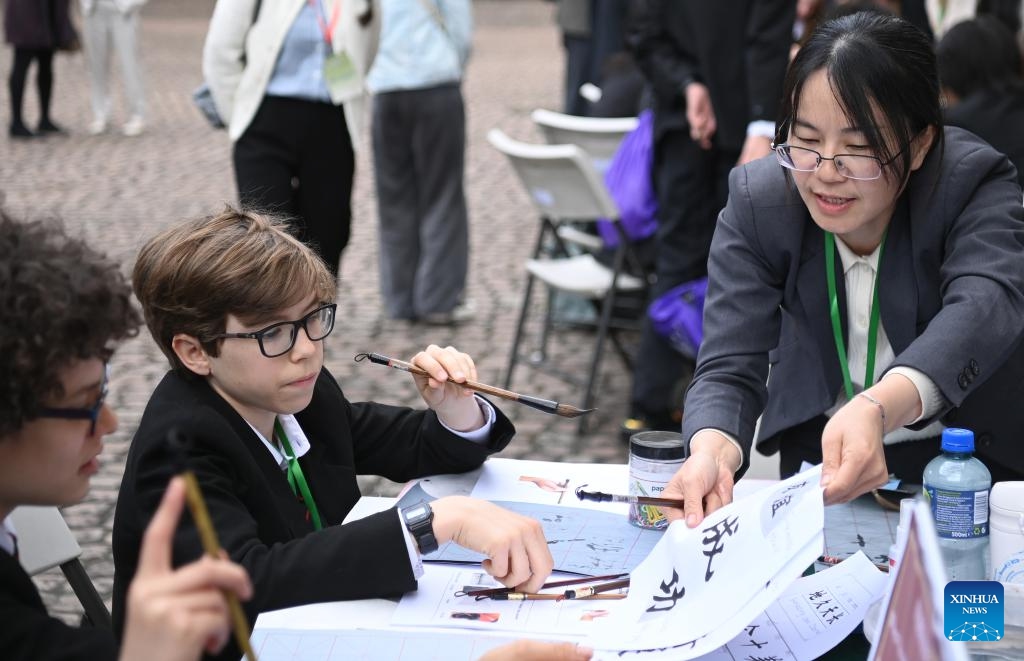 Students attend a Chinese calligraphy workshop during an event marking Chinese Language Day in London, Britain, on May 8, 2025. An event marking this year's Chinese Language Day was held on Thursday in London, bringing together around 100 students from six schools across Britain to celebrate the Chinese language and culture. (Photo: Xinhua)