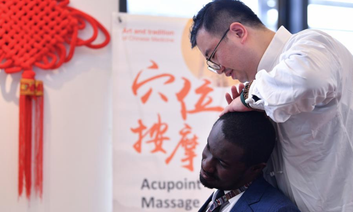 A participant enjoys acupoint massage during an event featuring traditional Chinese medicine at Palais des Nations in Geneva, Switzerland, Oct. 28, 2024. (Xinhua/Lian Yi)