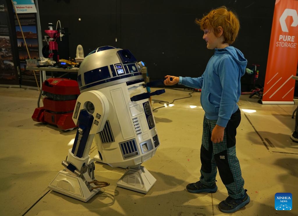 A boy interacts with a robot during the Maker Faire Prague 2025 in Prague, the Czech Republic, May 11, 2025.
