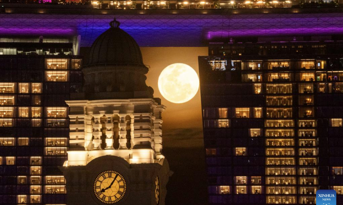 A full moon rises behind the clock tower of the Victoria Theatre and Victoria Concert Hall in Singapore on May 13, 2025. (Xinhua/Then Chih Wey)